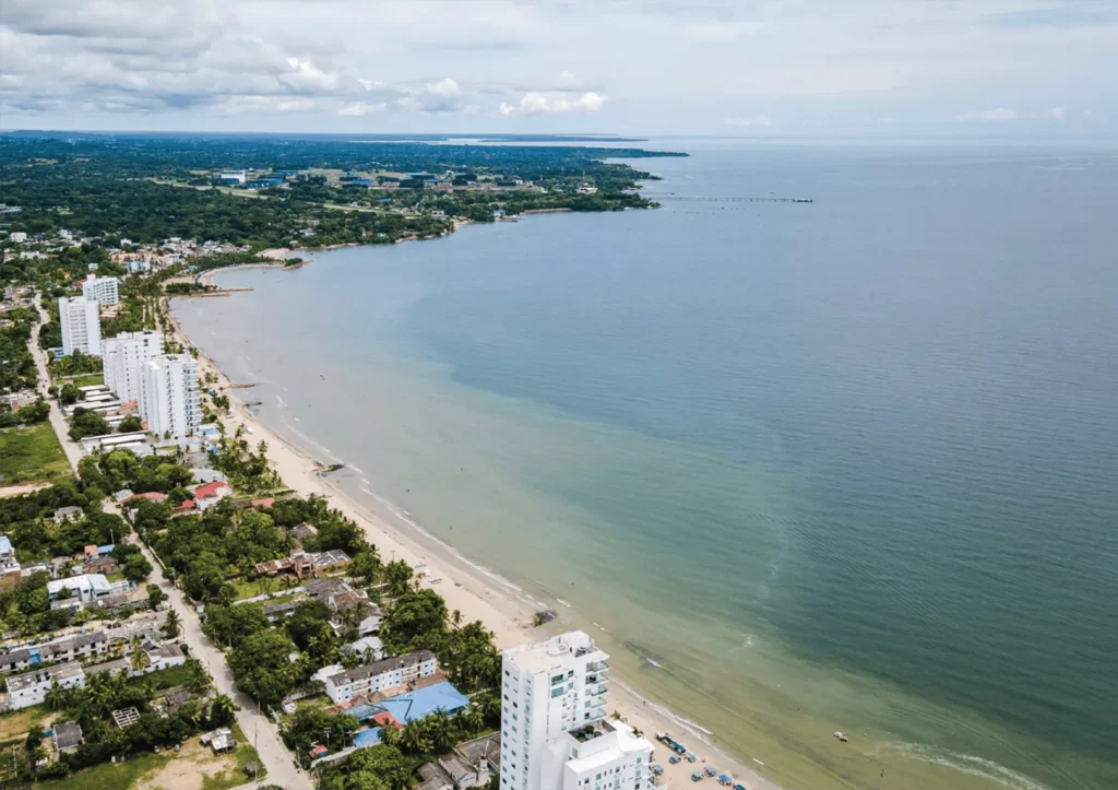 Vista aérea de la costa de Local Smiles con edificios residenciales, playa y mar azul.